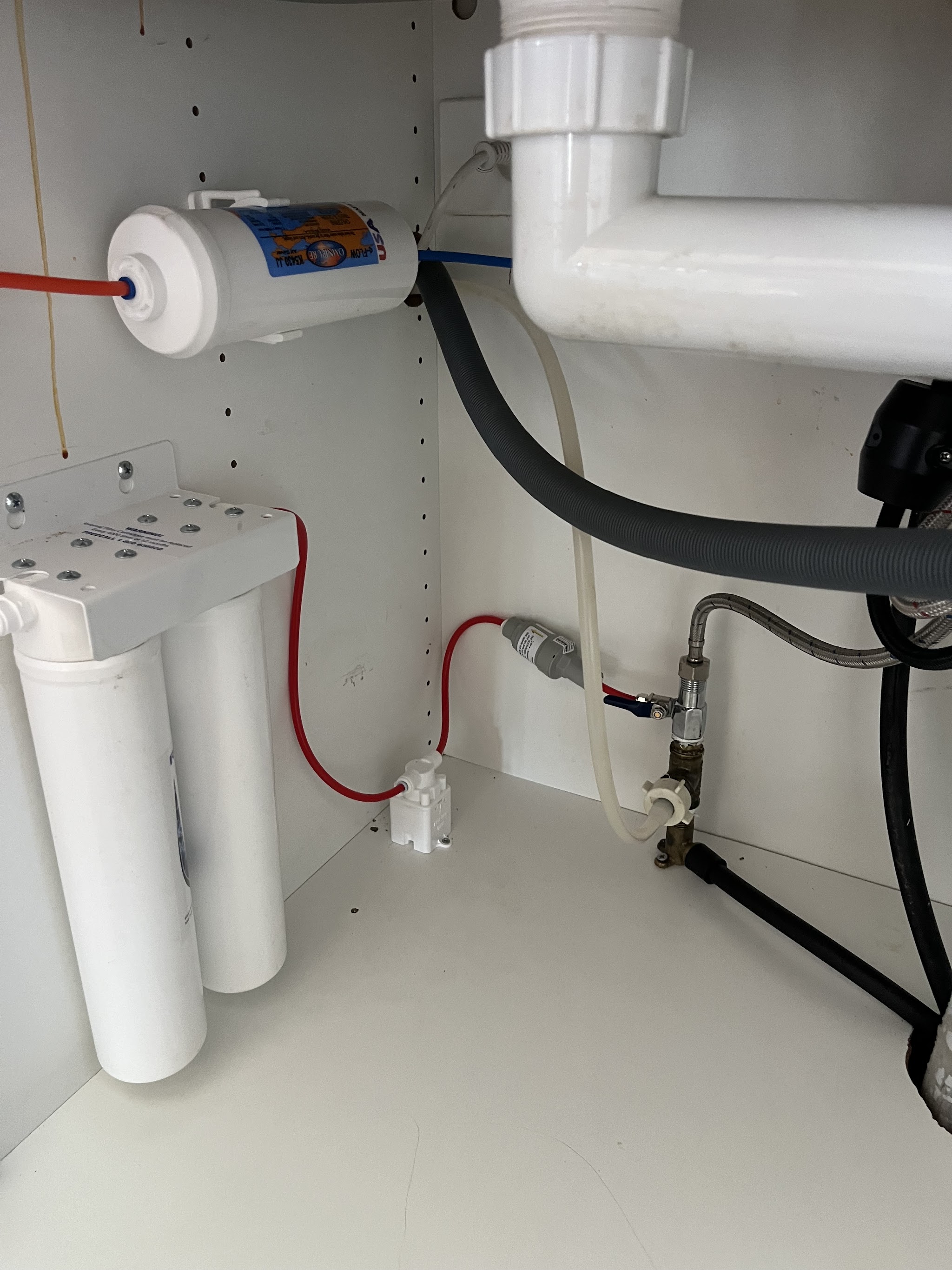 Twin cartridge water filtration system installed neatly under a kitchen sink
